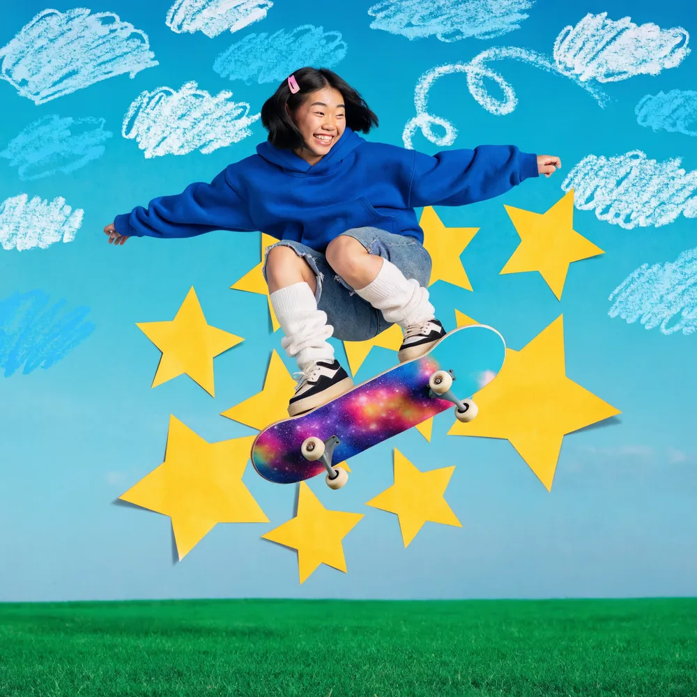 Playful blue hoodie skateboard campaign with yellow paper stars, chalk clouds, and a vivid cyan backdrop.
